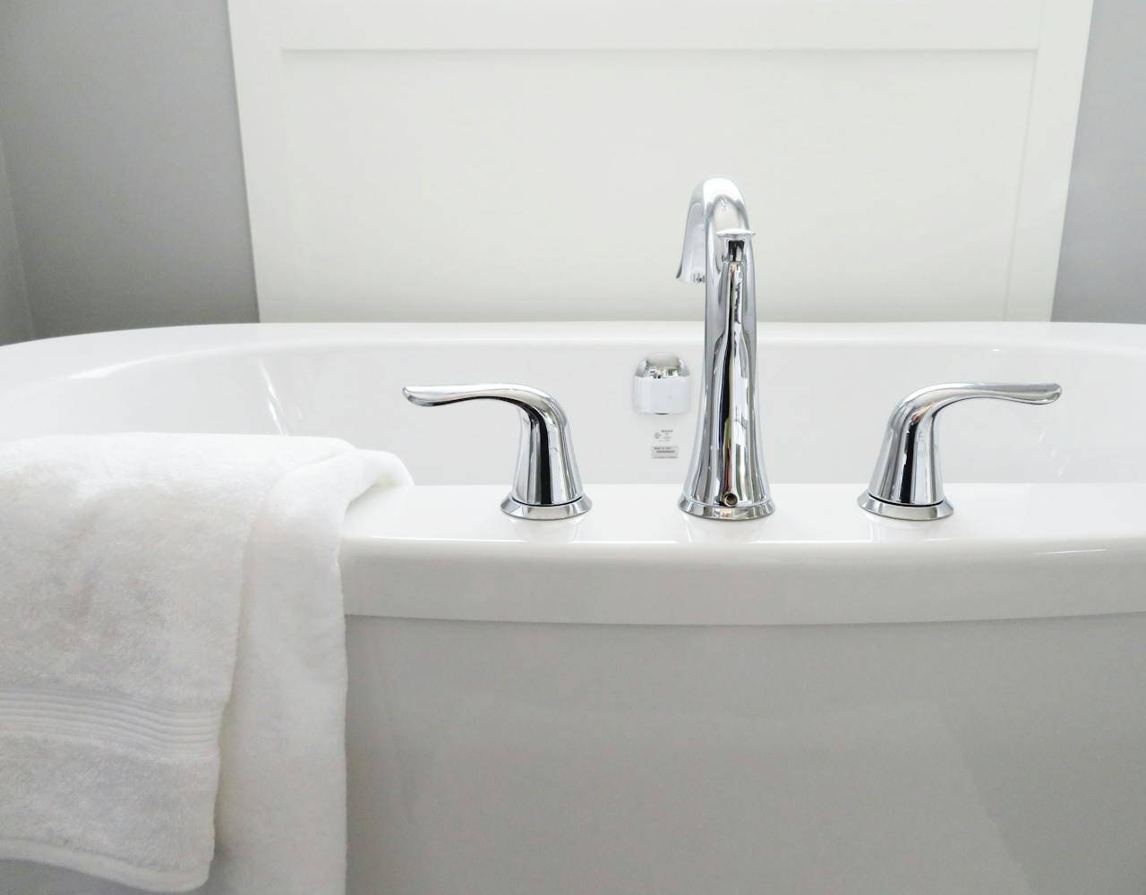 Clean and modern white bathtub with chrome fixtures, perfect for sleek interior design.